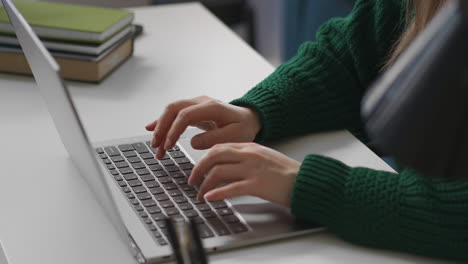 woman-office-worker-is-typing-text-on-keyboard-of-modern-laptop-closeup-of-hands-on-table-work-with-program-in-internet-freelance-and-part-time-job